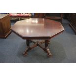 An Edwardian mahogany octagonal centre table on four reeded supports with scroll feet and castors,