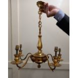 A brass chandelier baluster stem with five scroll branches and rams head mounts, 48cm