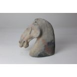 A Chinese pottery model of a horse head, possibly Han Dynasty, of stylized form, 19cm high