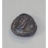 A tetradrachm coin, the obverse with head of Athena, the reverse with owl and olive twig, AOE to