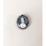 An 18th century oval portrait miniature of a lady with a pearl necklace and pink rose, possibly by