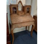 A French walnut bureau de dame with central mirror and two galleried cabinet surmount above fall