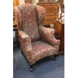 A Georgian style wingback armchair, upholstered in red floral damask style fabric, on cabriole