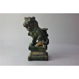 A Chinese pottery figure of a seated Dog of Fo in green and and orange glaze, 26cm