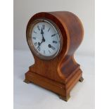 An oak balloon cased mantle clock, the circular white dial with Roman numerals, striking on a