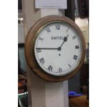 A circular oak wall clock with white dial and Roman numerals marked Enfield 40cm
