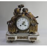 A gilt metal and marble mantle clock, the case flanked with winged cherubs, the base raised on metal