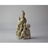 A Japanese carved ivory okimono of a woman and seated youth 10.5cm