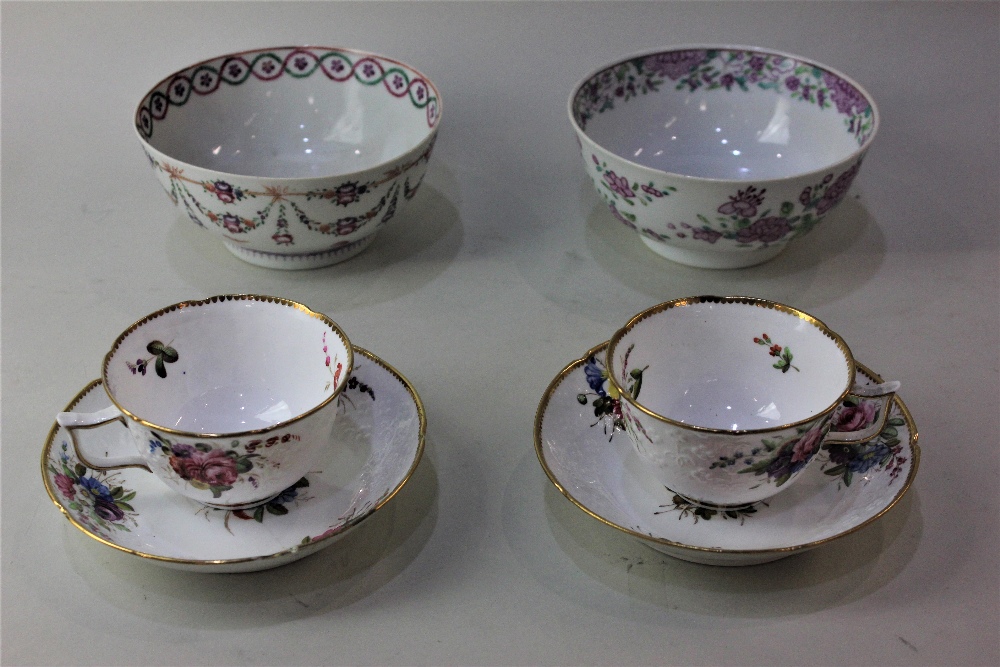 A pair of Spode porcelain tea cups and saucers with moulded floral decoration and gilt borders