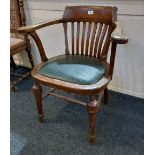 A Captains armchair with slatted back and upholstered seat on turned legs