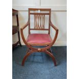 An X-framed elbow with lattice back and upholstered seat