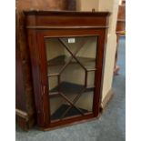 A small Edwardian mahogany hanging corner wall cabinet with chequered banding, the glazed panel door