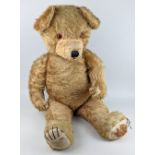 A large straw stuffed teddy bear, with hinged limbs, 88cm high (a/f)