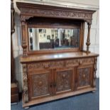 A Victorian carved oak sideboard with moulded cornice scroll carved frieze and mirror back on