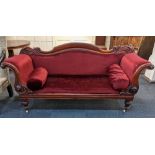 A Victorian scroll-end settee, with red upholstery and two matching bolster cushions, carved show