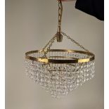 A circular brass five tier chandelier light fitting with hanging glass droplets 30cm diameter