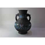 A Chinese bronzed metal two handled vase baluster shape with dragon headed handles and banded blue