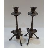 A pair of cast bronzed metal candlesticks with urn sconces on narrow reeded stems and three