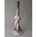 A 19th century porcelain candlestick converted to a table lamp, depicting a cherub representing