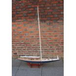 A scratch built model yacht, J class, raised on wooden stand, 153cm by 114cm including stand