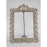 A rectangular brass picture frame, with pierced scrolling foliate decoration, easel back, for a 35cm