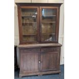 An Edwardian oak bookcase by Jas Shoolbred & Co. with glazed double door top enclosing three shelves
