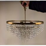 A circular brass six tier chandelier light fitting with hanging glass droplets, 43cm diameter