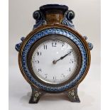 A Doulton Lambeth moon shaped mantle clock by Emily Welch, with circular enamel dial surmounted by a