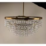 A circular brass six tier chandelier light fitting with hanging glass droplets, 43cm diameter