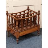 A Victorian canterbury / magazine rack with three divisions and base drawer on four turned legs