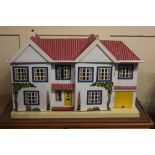 A Tri-ang white painted wooden dolls house, the hinged facade with nine windows, central yellow