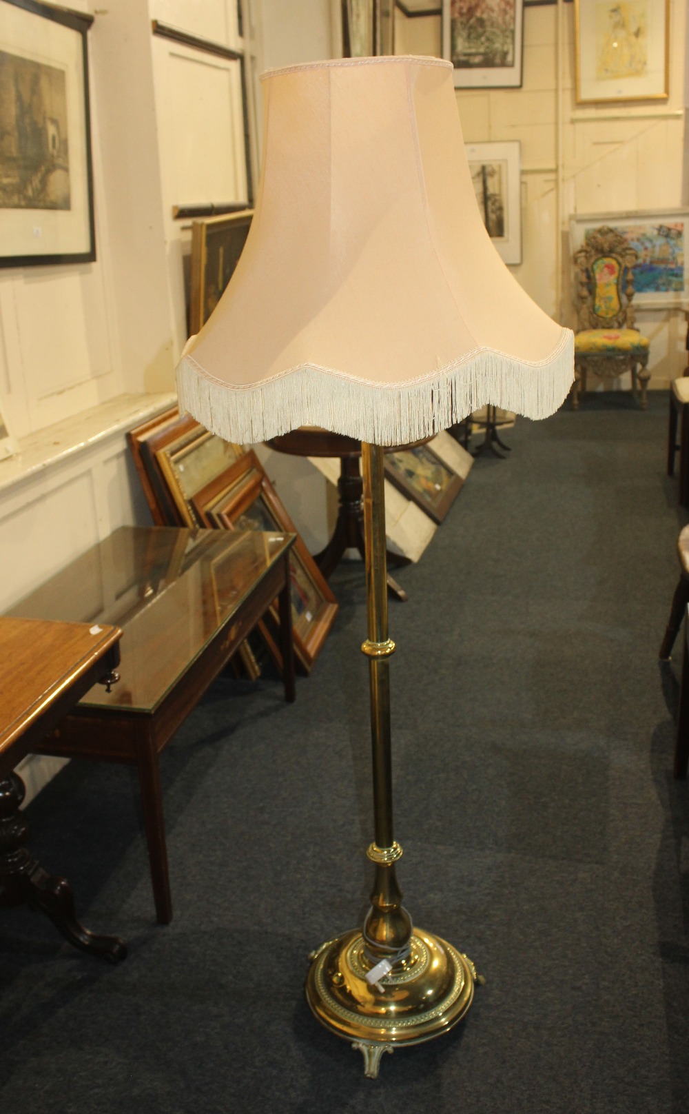 A Victorian brass telescopic standard lamp on circular base with gadrooned border and three scroll