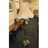 A Victorian brass telescopic standard lamp on circular base with gadrooned border and three scroll