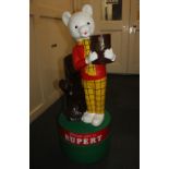 A floor standing donation money box moulded in the form of Rupert Bear, 98cm high