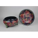 A Moorcroft pottery pomegranate pattern bowl and dish, decorated with pomegranates and berries on