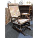 An early 20th century rocking chair with upholstered back and seat, padded arms on rcker base with