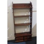 A Chippendale style floor standing four-tier shelf pierced sides and base with four small drawers,