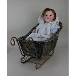 An Armand Marseille bisque head doll with sleeping blue eyes and open mouth revealing two teeth,