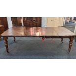 A Victorian mahogany extending dining table, with two extra leaves, the rectangular moulded top with