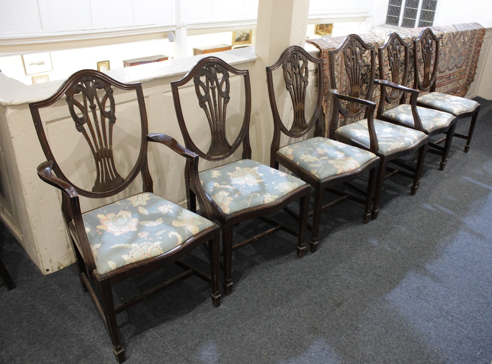 A set of six Sheraton style shield back dining chairs with carved Prince of Wales feathers pierced