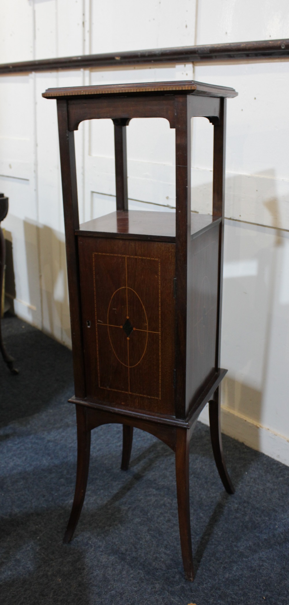 An Edwardian inlaid mahogany pot stand with square top and central cupboard with inlaid geometric