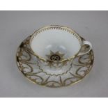 A Worcester fluted tea cup and saucer decorated with blue and gilt laurel swag border and star