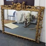 A large ornate gilt framed rectangular wall mirror with shell and twin putti surmount and pierced