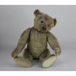 An early 20th century Steiff teddy bear, with button to ear, black eyes, stitched nose, mouth and