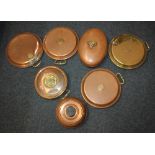 A collection of seven copper and brass hot water bottles