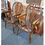 A pair of Windsor armchairs with pierced wheel backs, solid seats, on turned legs