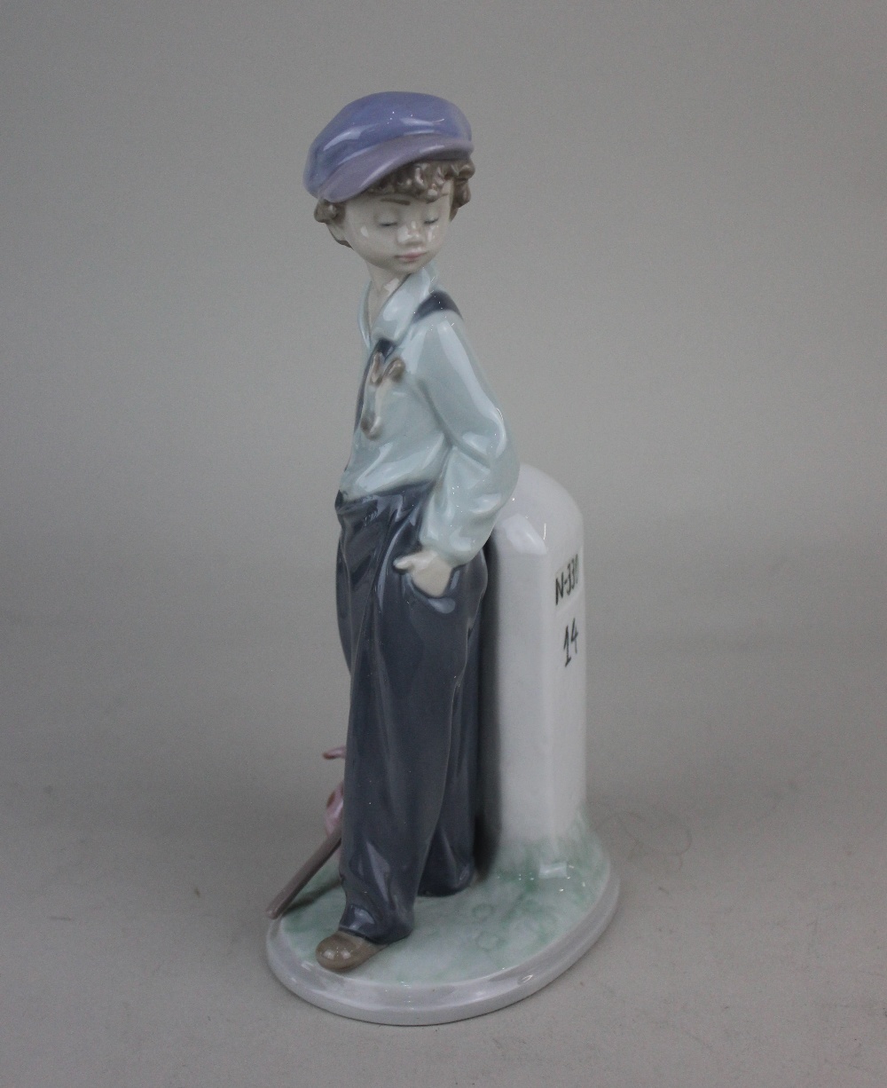 A Lladro porcelain figure of a boy 'The Wanderer', 21cm high, with box