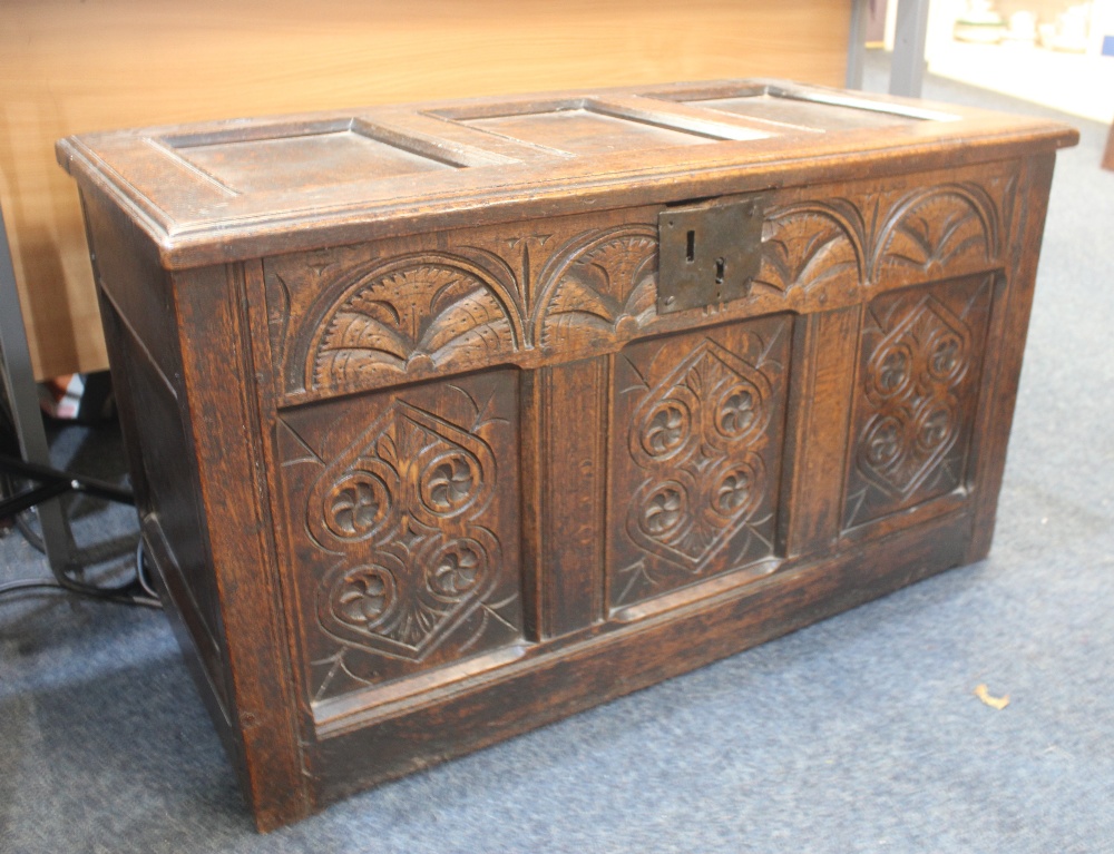 An 18th century carved oak coffer with carved three panel front, 98cm