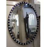 An Irish style oval wall mirror with blue and white alternate panel border, 90cm by 65cm