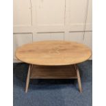 An Ercol light elm oval coffee table with undertier (a/f) 99cm